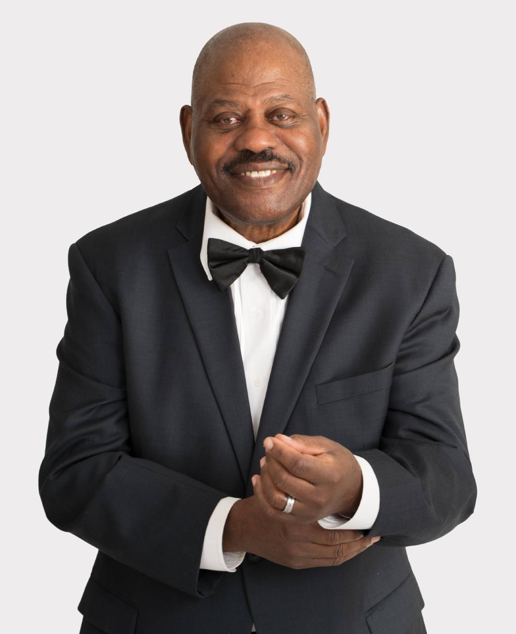 A man in a suit and bow tie clapping