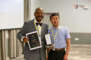Two men proudly holding awards, smiling.