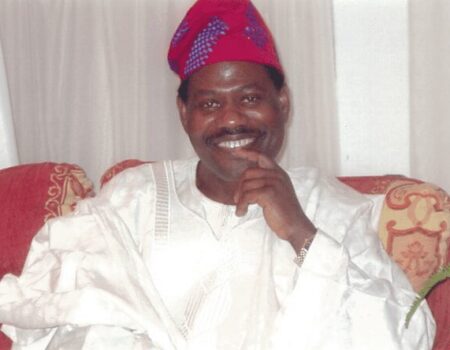 Smiling man with red cap, hand on chin